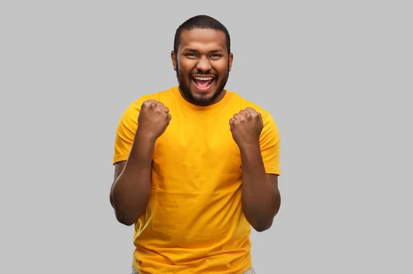 Усміхнений афроамериканський чоловік святкує успіх — стокове фото