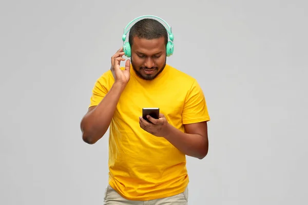 戴耳机和智能手机的非洲男人 — 图库照片