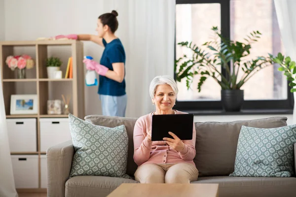 Stará žena s tabletem PC a hospodyně doma — Stock fotografie