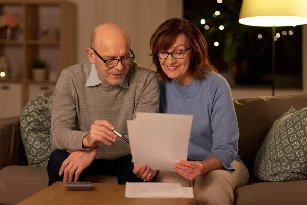Couple aîné avec papiers et calculatrice à la maison — Photo