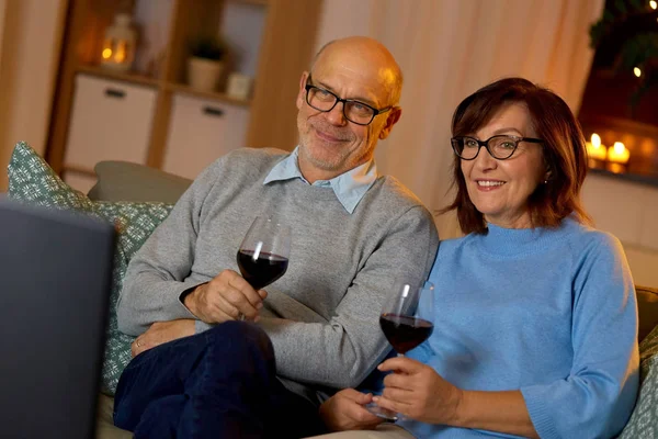Mutlu son sınıf çifti kırmızı şarap içip televizyon izliyor. — Stok fotoğraf