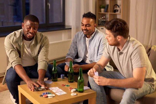 Sonrientes amigos varones jugando a las cartas en casa — Foto de Stock