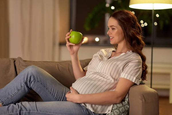 Mujer embarazada feliz con manzana verde en casa —  Fotos de Stock