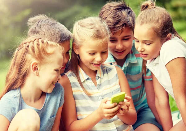 Barn eller vänner med smartphone i sommaren park — Stockfoto