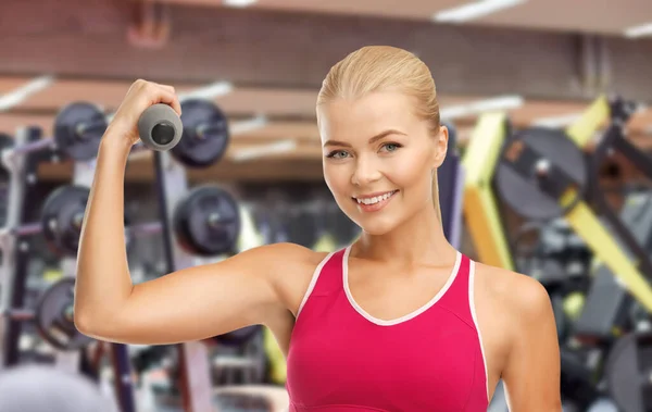 Glad ung kvinna med hantlar som tränar på gym — Stockfoto