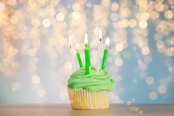 Green cupcake with six burning candles on table — Stock Photo, Image
