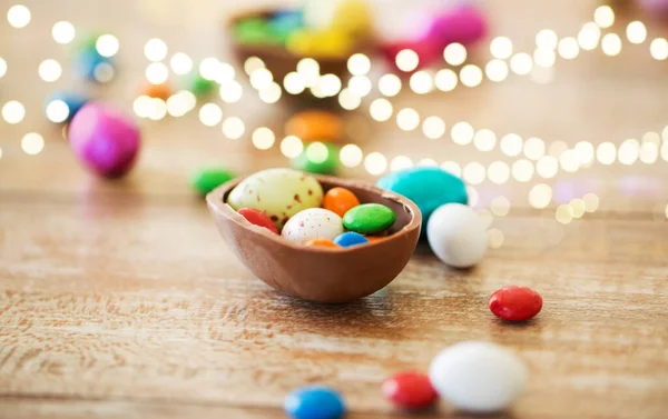 Chocolate huevo de Pascua y dulces gotas en la mesa — Foto de Stock