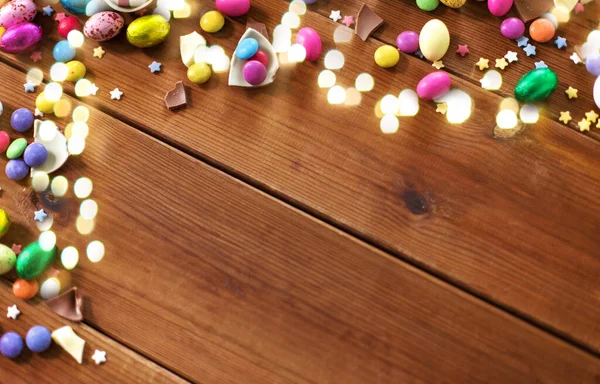 Huevos de chocolate y gotas de caramelo en mesa de madera — Foto de Stock