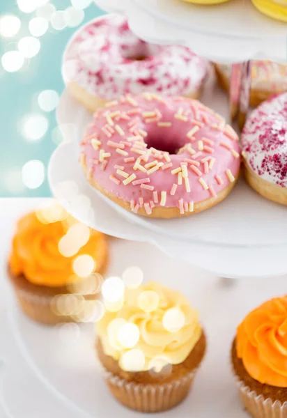 Close up de donuts envidraçados e cupcakes em stand — Fotografia de Stock
