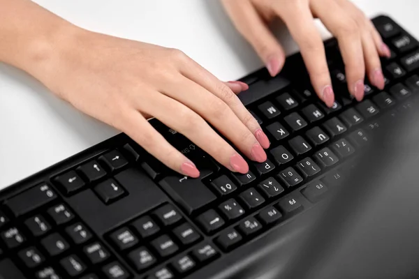 Female hands typing on computer keyboard on table — Stock Photo, Image