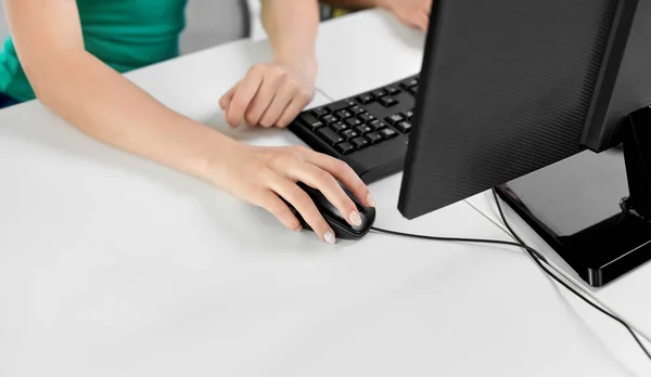 Mano femenina con ratón de ordenador en la mesa —  Fotos de Stock