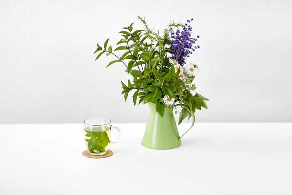 Herbal tea and flowers in jug — Stock fotografie