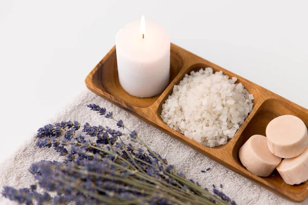 Sal marinho, sabão, vela e lavanda na toalha de banho — Fotografia de Stock