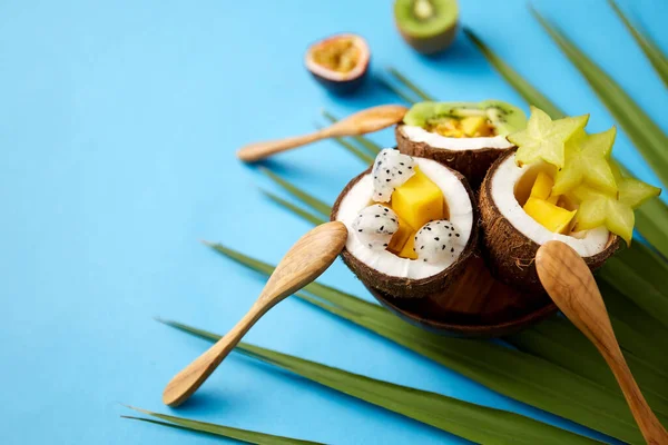 Mix di frutta esotica in gusci di cocco con cucchiai Fotografia Stock