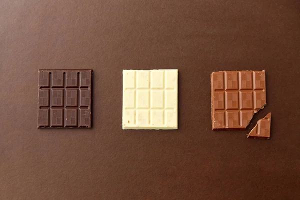 Différents types de chocolat sur fond brun — Photo