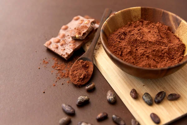 Chocolate with hazelnuts, cocoa beans and powder — Stock Photo, Image