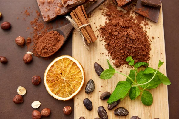 Chocolate con avellanas, granos de cacao y polvo — Foto de Stock