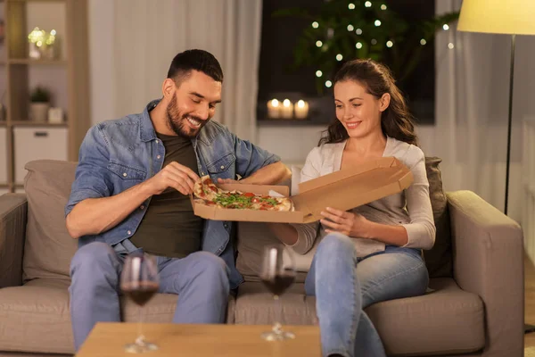 Casal feliz comer pizza takeaway em casa — Fotografia de Stock