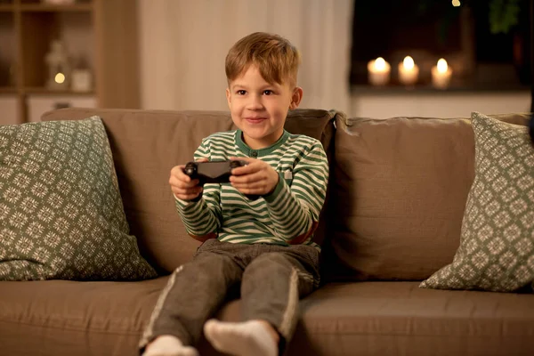 Liten pojke med gamepad spelar TV-spel hemma — Stockfoto