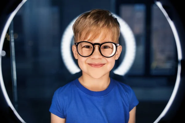 Menino em óculos sobre a iluminação no quarto escuro — Fotografia de Stock