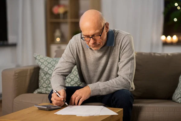 Senior man with bills and calculator at home — Stock Photo, Image