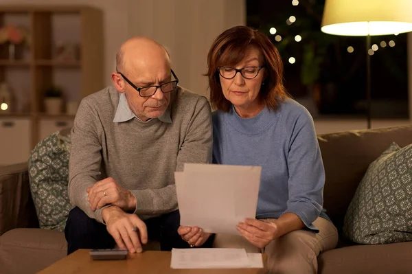 Seniorenpaar mit Papieren und Taschenrechner zu Hause — Stockfoto