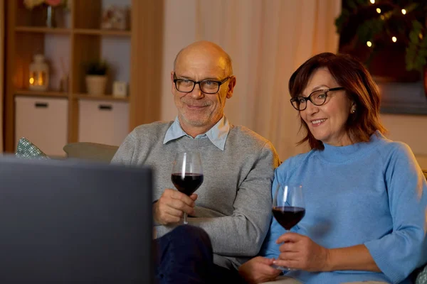 Gelukkig senior paar drinken rode wijn en tv kijken — Stockfoto