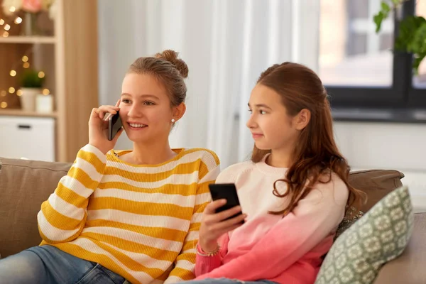 Glada tonårstjejer med smartphones hemma — Stockfoto
