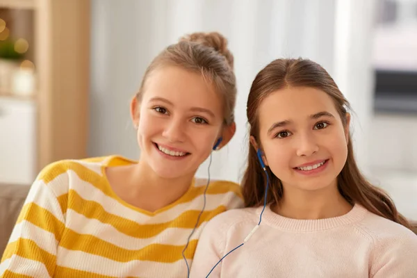 Happy girls with earphones listen to music at home — Stock Fotó