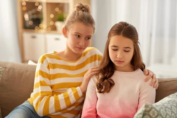 Teenage girl comforting her sad friend at home — Stock Photo, Image