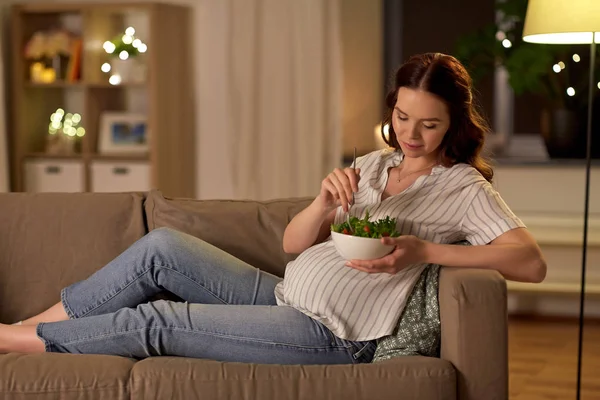 Glücklich lächelnde Schwangere, die zu Hause Salat isst — Stockfoto