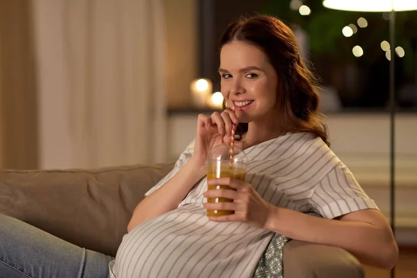 Mulher grávida feliz beber suco em casa — Fotografia de Stock