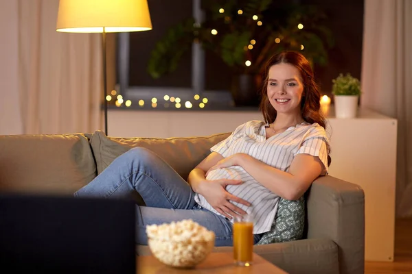 Heureux souriant femme enceinte regarder la télévision à la maison — Photo