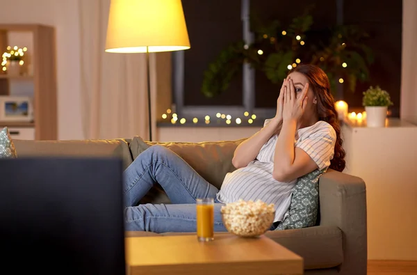 Φοβισμένη έγκυος γυναίκα βλέποντας τηλεόραση στο σπίτι — Φωτογραφία Αρχείου