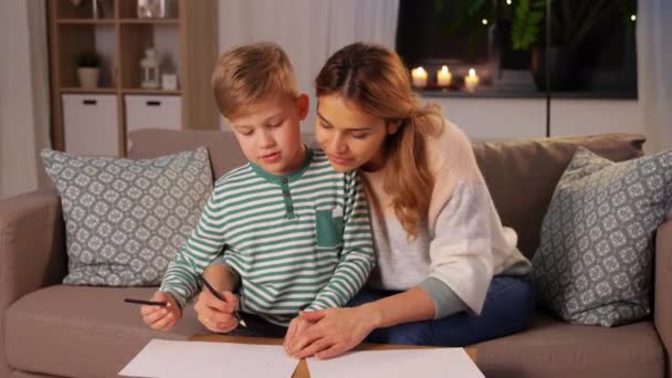 Mother and son with pencils drawing at home — Stockvideo