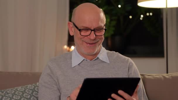 Ευτυχισμένος ηλικιωμένος άνδρας με tablet υπολογιστή στο σπίτι — Αρχείο Βίντεο