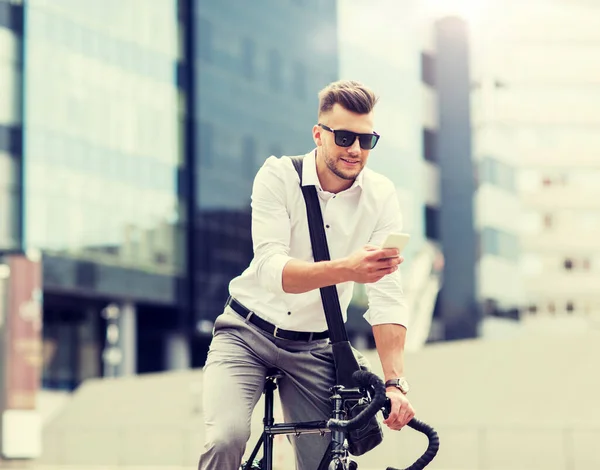 Человек с велосипедом и смартфоном на городской улице — стоковое фото