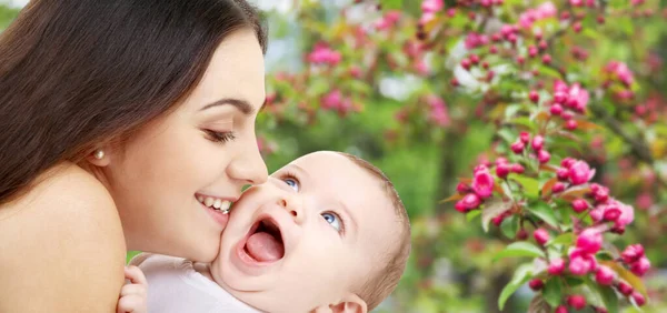 Mãe com bebê sobre o fundo do jardim primavera — Fotografia de Stock