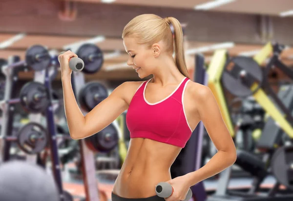 Glad ung kvinna med hantlar som tränar på gym — Stockfoto