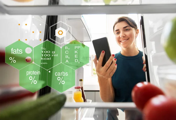 Donna con smartphone e cibo in frigo — Foto Stock