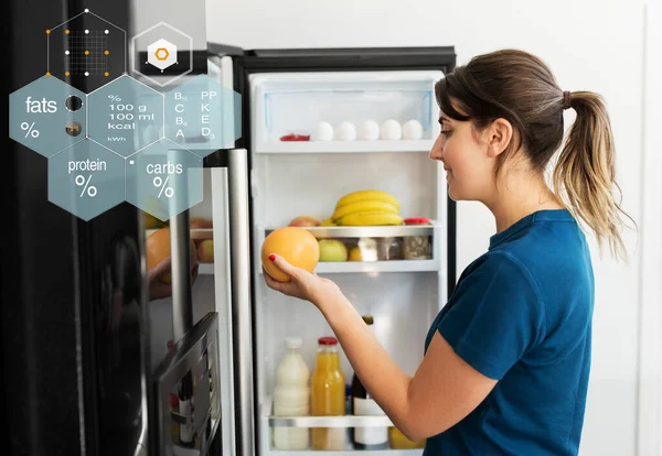 Femme heureuse prenant de la nourriture du réfrigérateur à la maison — Photo