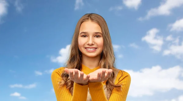 Nastolatka dziewczyna trzyma coś na pustych rękach — Zdjęcie stockowe