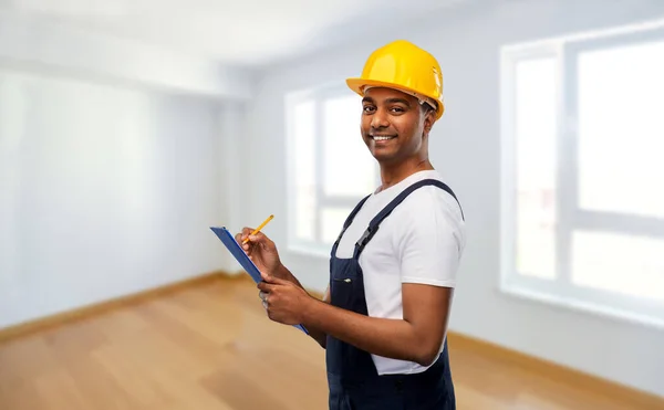 Construtor feliz no capacete com prancheta e lápis — Fotografia de Stock