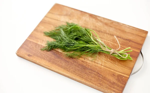 Bunch of dill on wooden cutting board — Stock fotografie