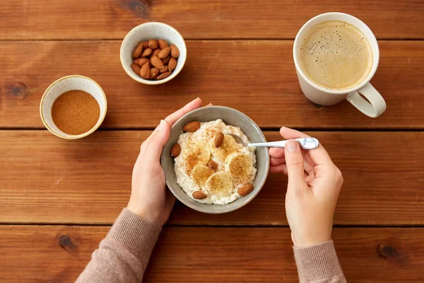 与燕麦片早餐和咖啡的手 — 图库照片