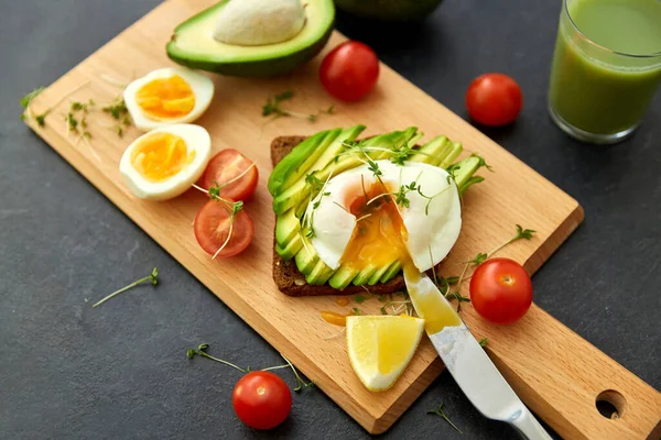 Pan tostado con aguacate, huevos y tomates cherry — Foto de Stock