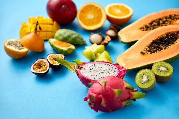 Diferentes frutas exóticas sobre fondo azul — Foto de Stock