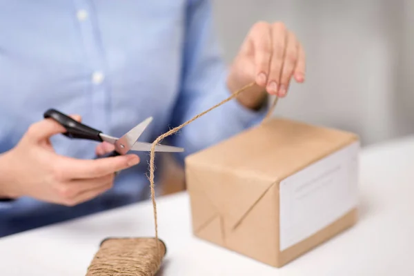 Frau mit Paketschneideseil bei Post — Stockfoto