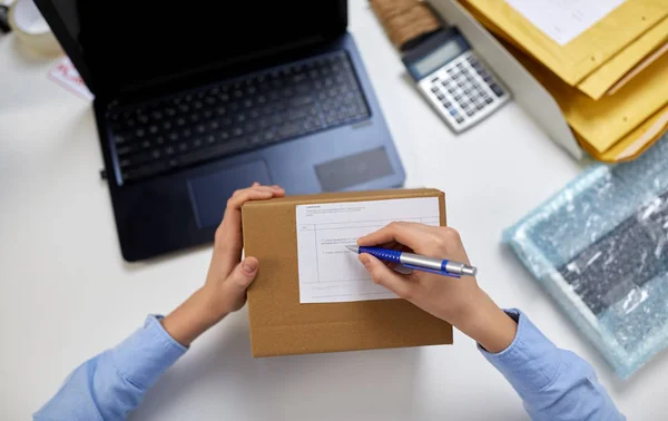 Fermer les mains remplir le formulaire sur le colis au bureau — Photo