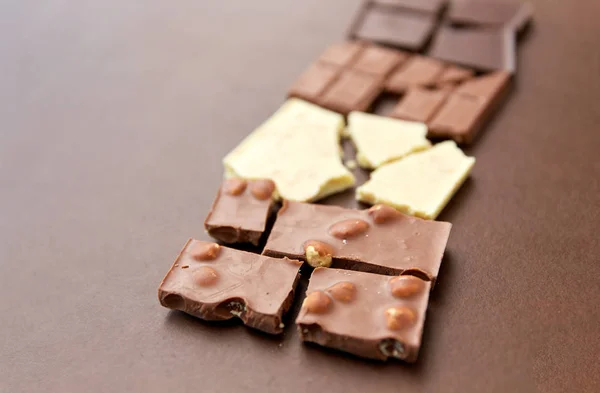 Berbagai jenis cokelat pada latar belakang coklat — Stok Foto